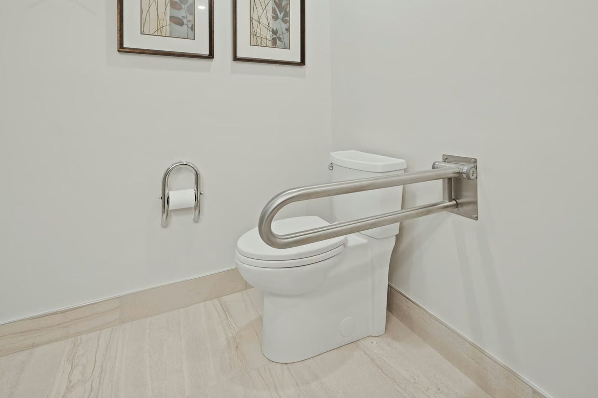 Banheiro acessível com barra de apoio articulada de aço inox ao lado do vaso