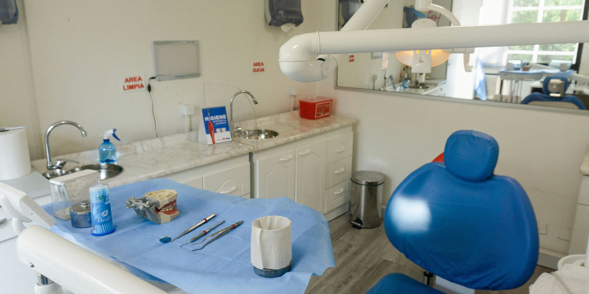 Consultório com lavatórios, bancada de instrumentos e cadeira azul
