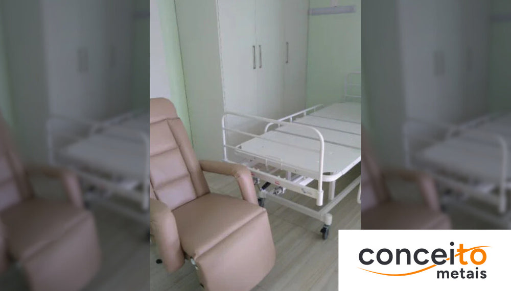 Quarto hospitalar com cama articulada equipada com grades laterais de segurança e poltrona reclinável de acompanhante...