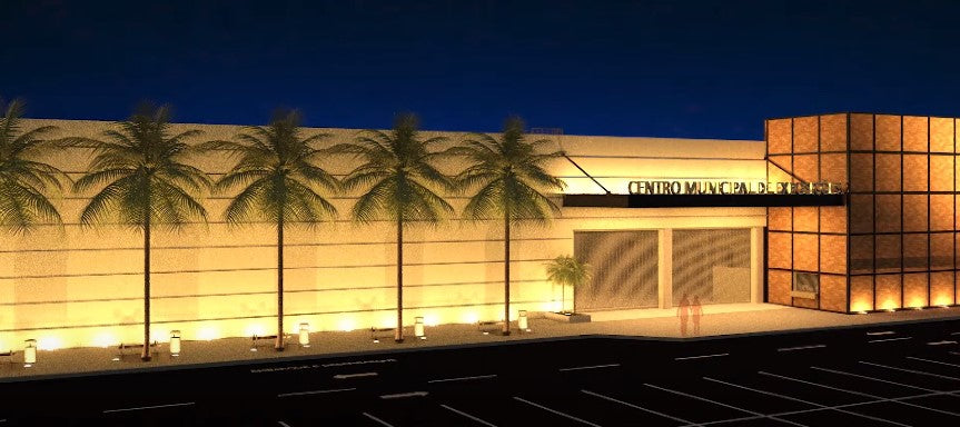 Vista noturna em render da fachada do Centro Municipal de Exposições, mostrando a iluminação externa e o acesso princ...